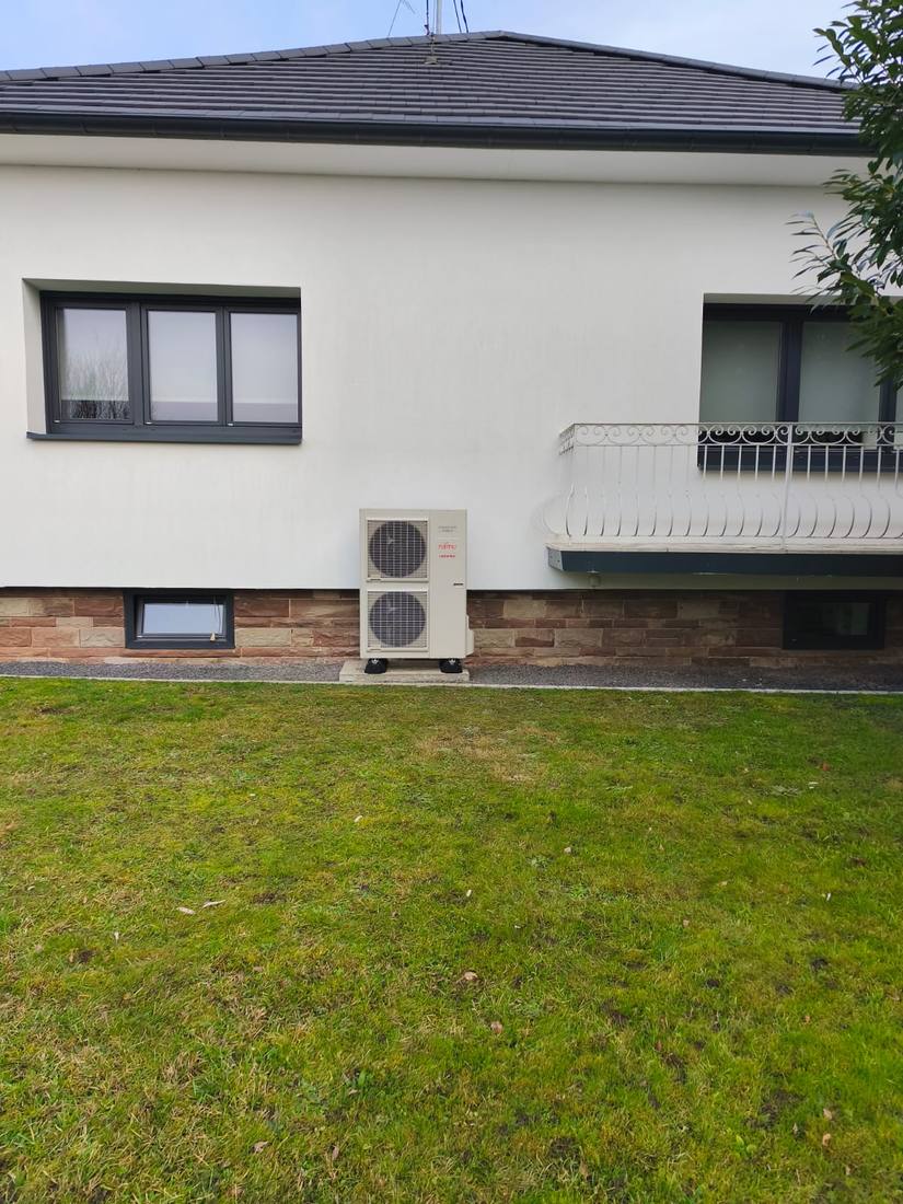 Unité extérieure de pompe à chaleur sur façade de maison