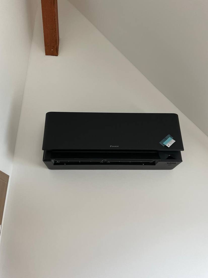 Climatiseur Daikin noir installé sous combles